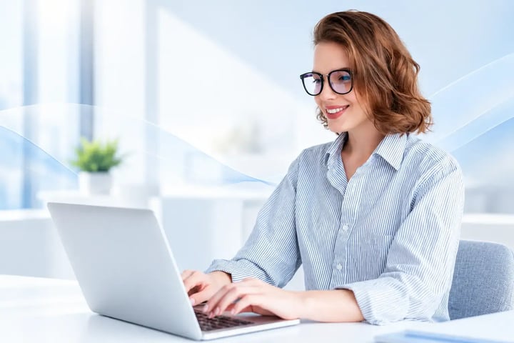 Mujer con camisa a rayas trabajando en su laptop